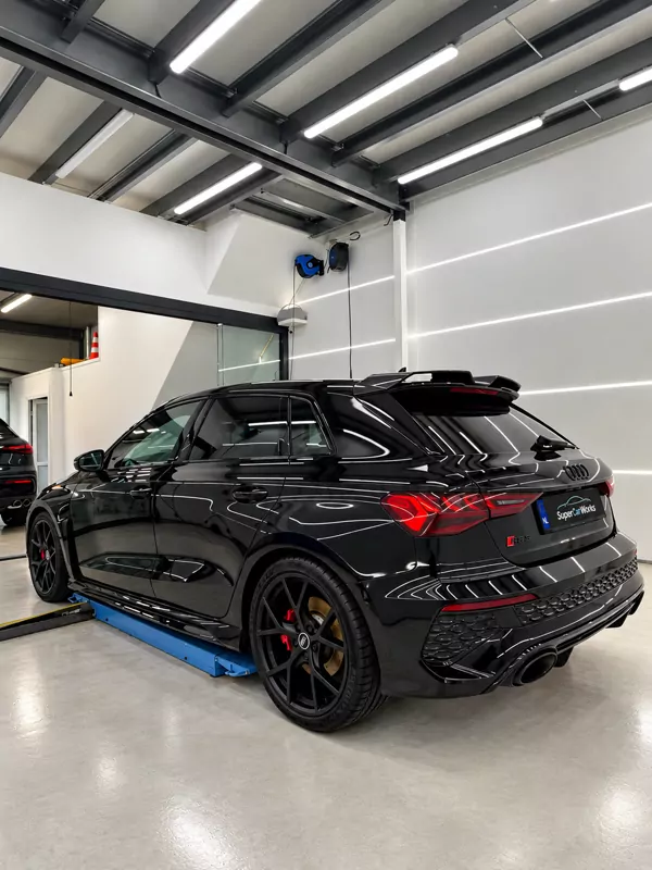 Zwarte Audi RS3 met rode remklauwen in de studio
