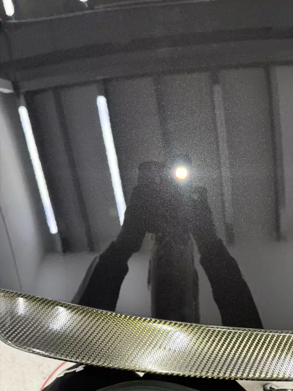 Reflectie in gepolijste lak boven een carbon spoiler